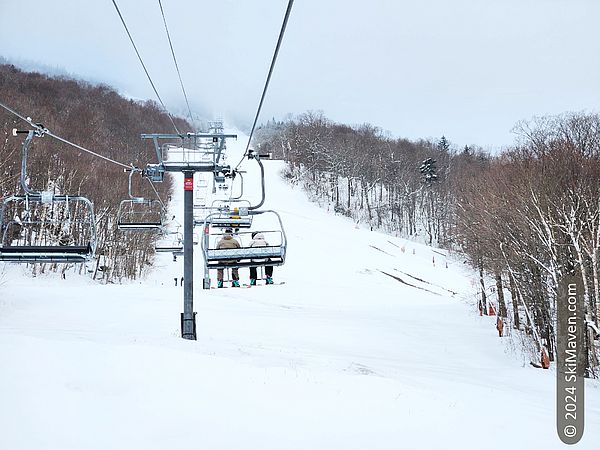 Riding the quad chairlift and some dirt showing on the slope below