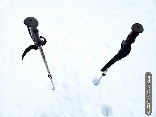 Two ski poles sticking out of some fresh snow